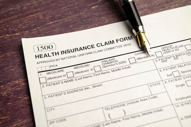 Health insurance form with pen on wooden background