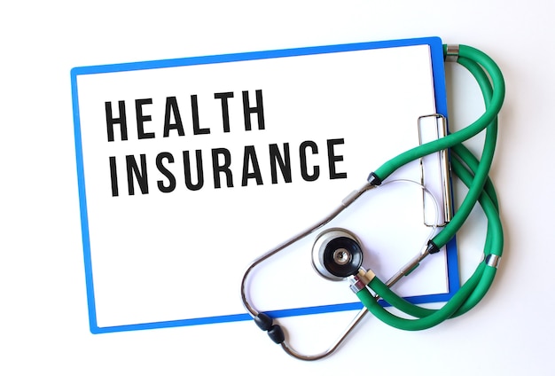 Photo health insurance text on medical folder with documents and stethoscope on white background. medical concept.