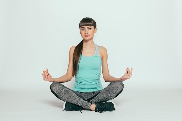 Health people Sport and lifestyle concept  Young happy fitness girl with sporty body at studio on a gray background Beautiful fit Girl Fitness model in gray sportswear Healthy lifestyle