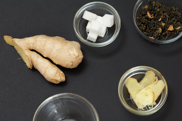 Health remedy foods for cold and flu relief with ginger and fruit tea on a black background