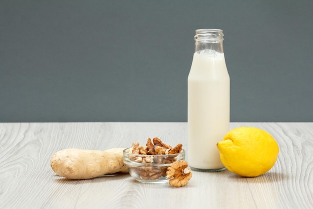 Health remedy relief foods and drink for cold and flu with lemon ginger and walnuts on wood boards