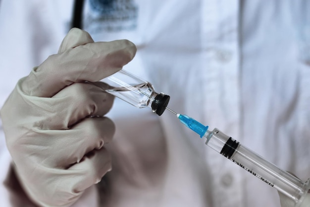 Health worker dials the vaccine into a syringe