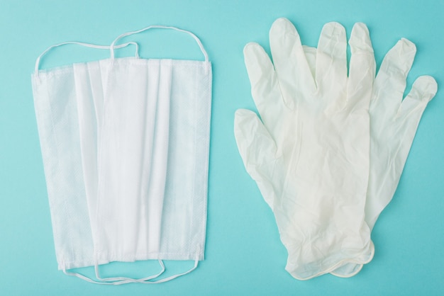 Healthcare during Coronavirus quarantine concept. Top above overhead flat lay view photo of masks and gloves isolated on turquoise background