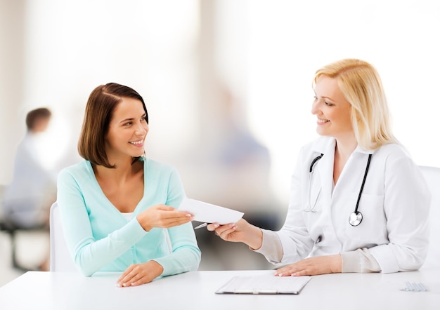 healthcare and medical concept - doctor giving prescription to patient in hospital