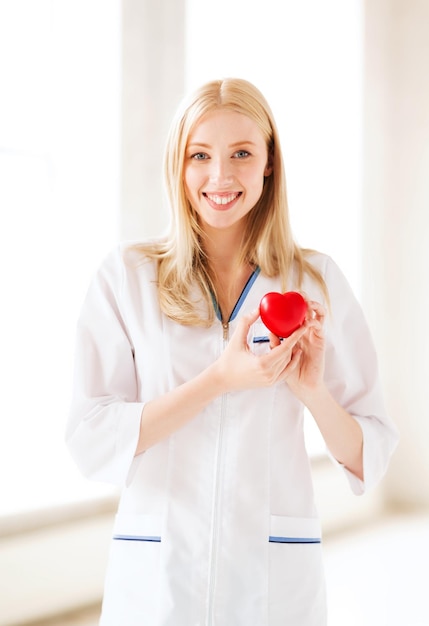 healthcare and medical concept - female doctor with heart