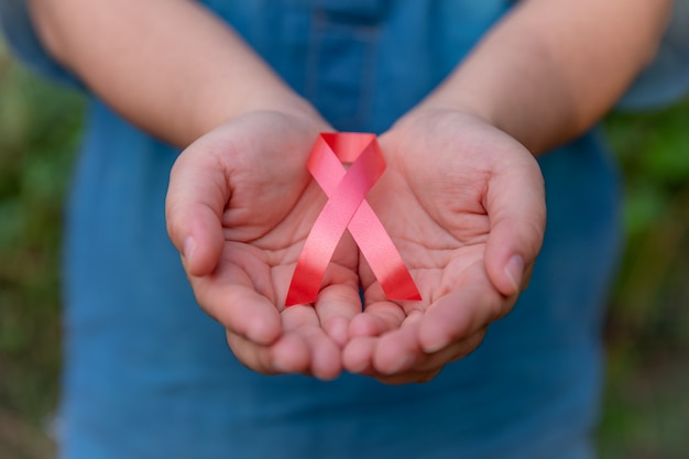 Healthcare and medical concept - Woman hand holding a red ribbon