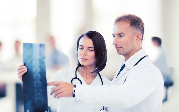 healthcare, medical and radiology concept - two doctors looking at x-ray