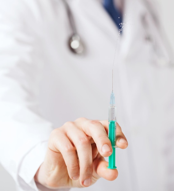 healthcare and medicine concept - close up of male hand holding syringe with injection