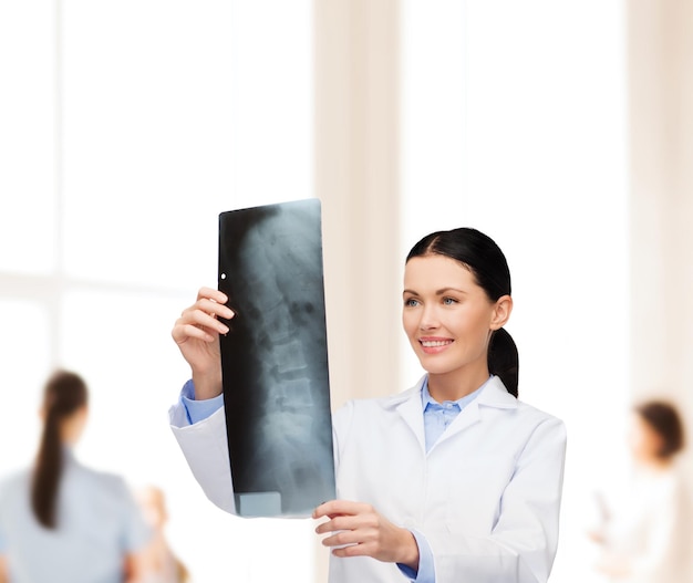 healthcare, medicine and radiology concept - smiling female doctor looking at x-ray