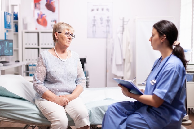 Healthcare nurse telling senior woman diagnosis about illness