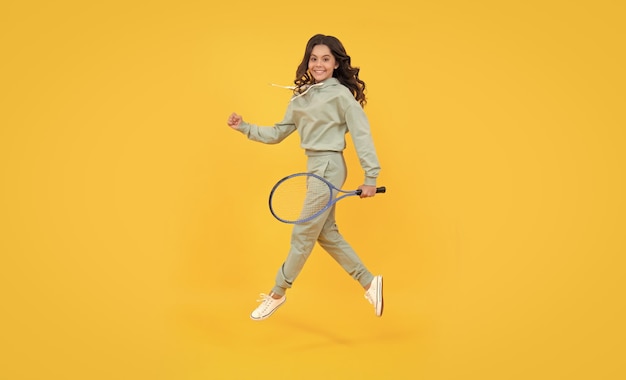 Healthy and active lifestyle sport success happy childhood kid jump with racket energetic child with tennis racquet teen girl run to training dedicated to fitness tennis or badminton player