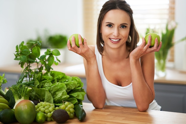 healthy adult woman with green food in the kitchen