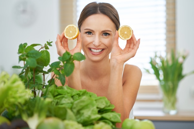 healthy adult woman with green food in the kitchen