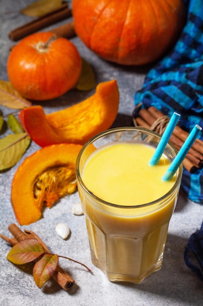 Healthy Autumn pumpkin smoothie with cinnamon in glass on a stone countertop