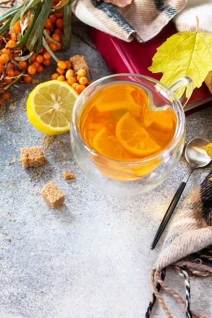 Healthy autumn vitamin drink Hot Sea buckthorn tea with lemon with sea buckthorn berries Copy space