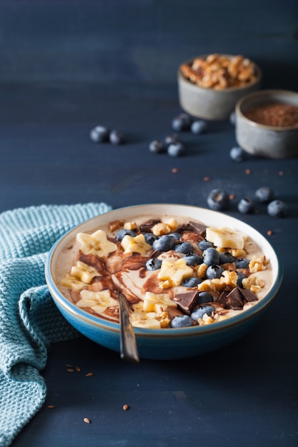 Healthy banana smoothie bowl with blueberry chocolate walnuts