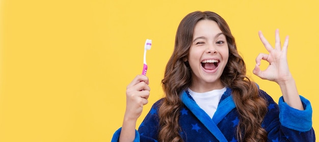 Healthy beautiful smile using best toothpaste childrens stomatology ok gesture Banner of child girl with teeth brush studio portrait header with copy space