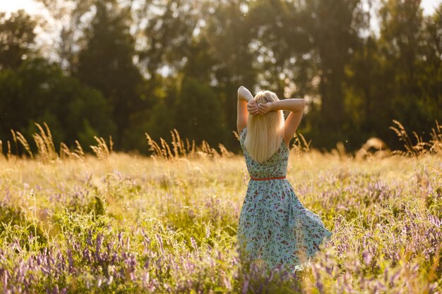 Photo healthy beautiful woman walking outdoors. alluring young woman in wheat field, delicate sensual woman on nature. perfect skin, curly hair.