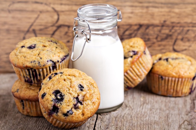 Healthy blueberry banana muffins with milk on a wooden table