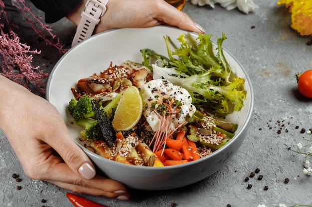 Healthy bowl quinoa salad with tuna broccoli avocado on wooden rustic table top view