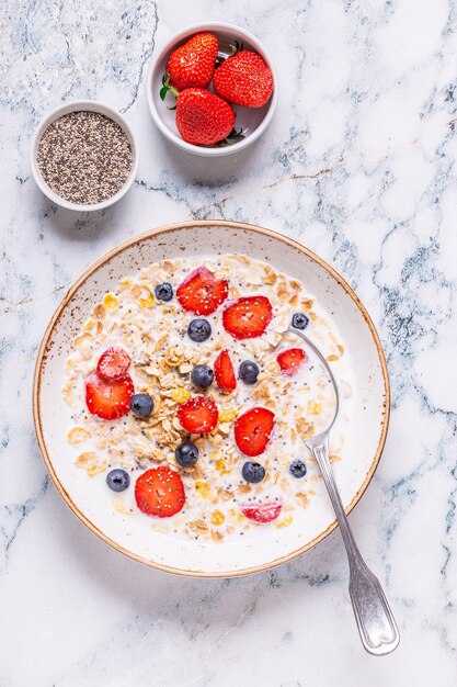 Healthy breakfast, bowl with oat granola, milk and berries