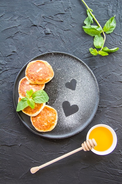 A healthy breakfast of cheese pancakes and honey. Creative atmospheric decoration