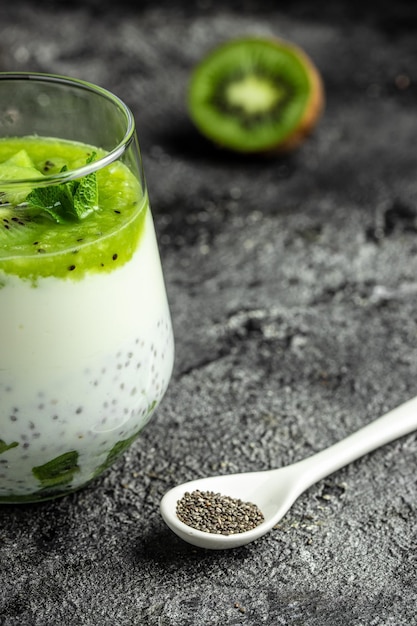 Healthy breakfast chia pudding with kiwi in glass jars on a white table Clean eating dieting vegan food concept vertical image