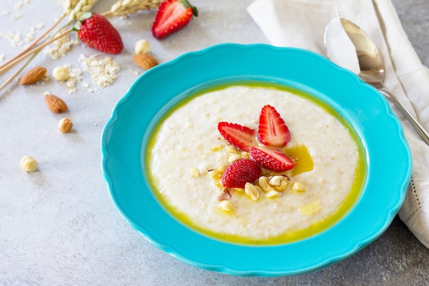 Healthy breakfast closeup Porridge of oatmeal with nuts and fresh strawberries Copy space