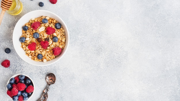 Healthy breakfast. Fresh granola, muesli with yogurt and berries on grey table. Copy space