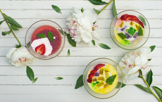 A healthy breakfast of milk jelly with fresh fruits in glass bowls on a rustic table