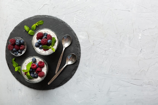 Healthy breakfast or morning with chia seeds vanilla pudding raspberry and blueberry berries on table background vegetarian food diet and health concept Chia pudding with raspberry and blueberry