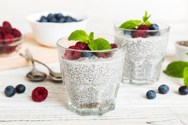 Healthy breakfast or morning with chia seeds vanilla pudding raspberry and blueberry berries on table background vegetarian food diet and health concept Chia pudding with raspberry and blueberry