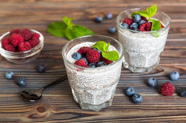 Healthy breakfast or morning with chia seeds vanilla pudding raspberry and blueberry berries on table background vegetarian food diet and health concept Chia pudding with raspberry and blueberry