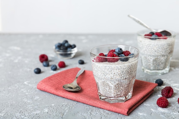 Healthy breakfast or morning with chia seeds vanilla pudding raspberry and blueberry berries on table background vegetarian food diet and health concept Chia pudding with raspberry and blueberry