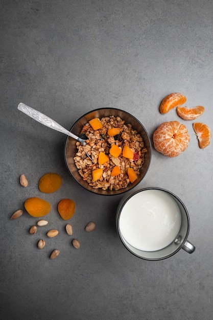 Healthy breakfast of muesli with fresh fruit and yogurt on a gray table