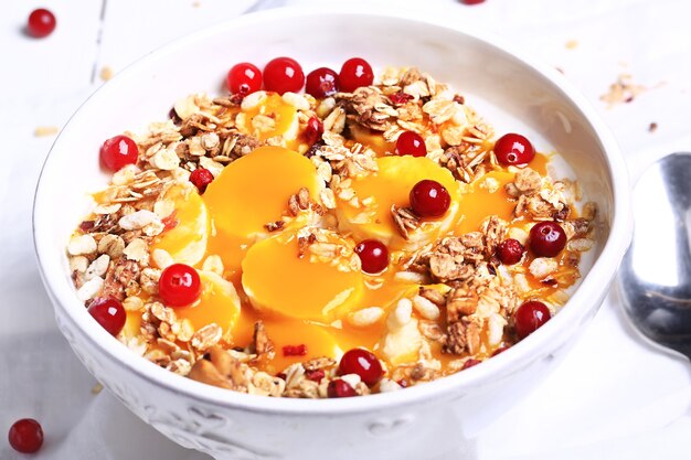 Healthy breakfast rice porridge with mango puree, banana and granola