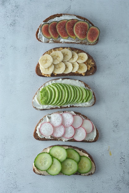 Healthy breakfast sandwiches with avocado, cucumber, fig fruit, banana, cream cheese.