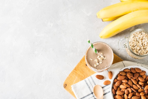 Healthy breakfast smoothie banana oatmeal almond milk on white background