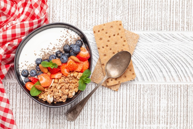 Healthy breakfast with bowl of granola yogurt and fresh berries