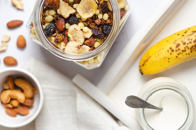 Healthy breakfast with granola and nuts in a glass jar top view