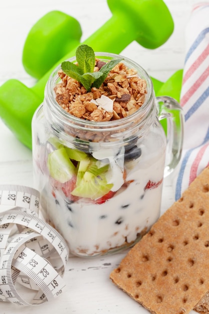 Healthy breakfast with jar of granola yogurt and fresh berries