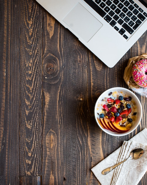 Healthy breakfast with milk,muesli and fruit, on a wooden background.