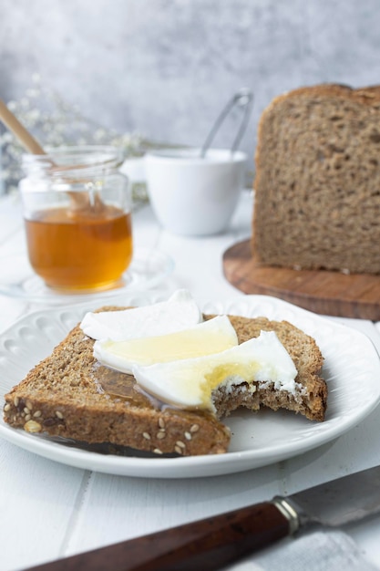 Healthy breakfast with wholemeal bread fresh goat cheese and raw honey A delicious breakfast