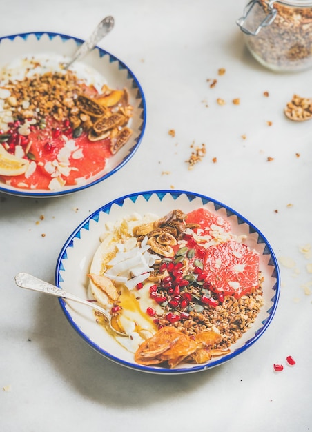 Healthy breakfast yogurt bowls over grey marble table background