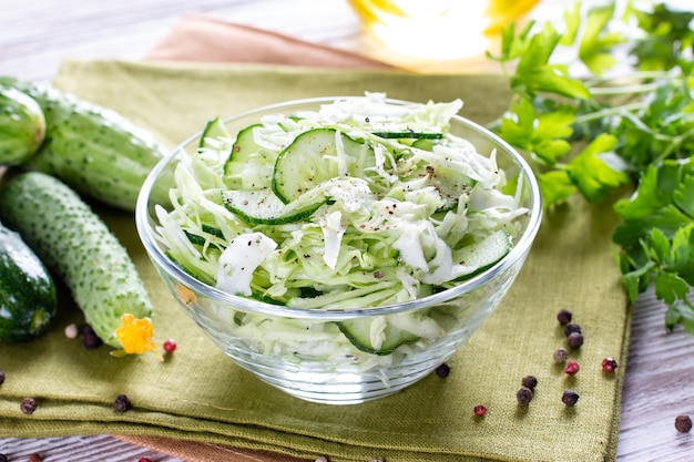 Healthy cabbage salad with cucumber, green onion and parsley on a plate. Diet food concept