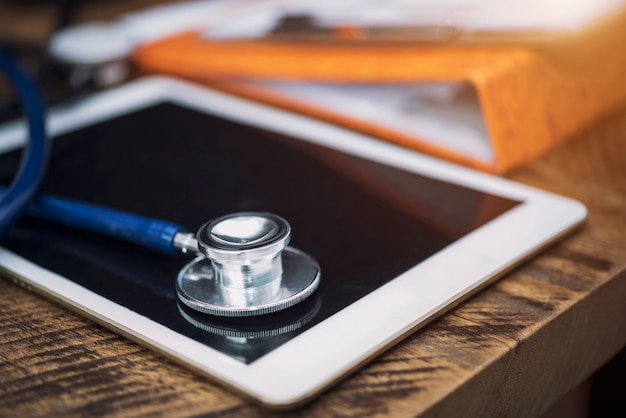 Photo healthy checking concept. stethoscope on tablet in office.