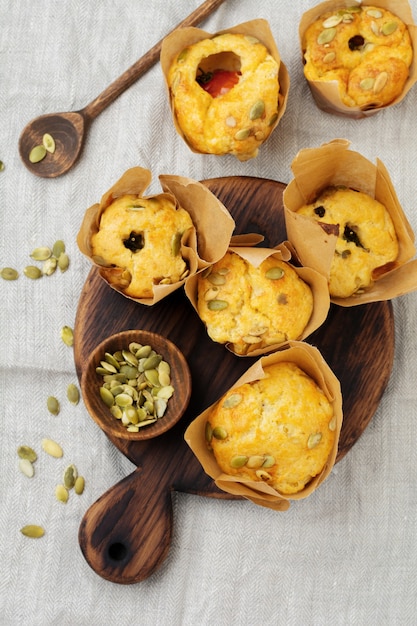 Healthy cheese muffins with polenta, cherry tomato and pumpkin seeds for breakfast. Selective focus. Top view. Copy space.