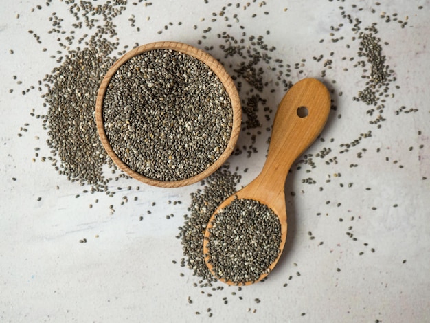 Healthy chia seeds in a wooden spoon on the table closeup