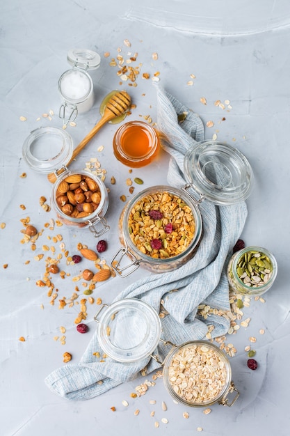 Healthy clean eating, dieting and nutrition, fitness, balanced food, breakfast concept. Homemade granola muesli with ingredients on a table. Top view flat lay background