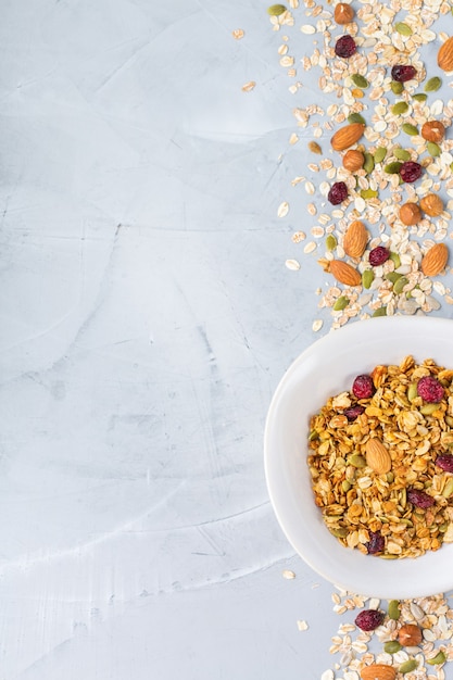 Healthy clean eating, dieting and nutrition, fitness, balanced food, breakfast concept. Homemade granola muesli with ingredients on a table. Top view flat lay copy space background